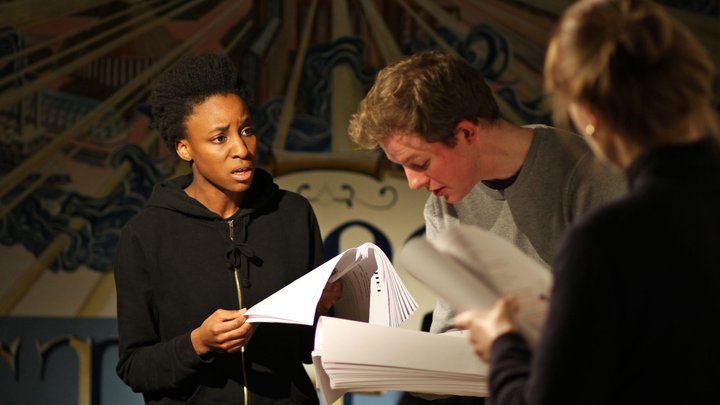 Three actors perform from scripts in the RADA bar. On the left, an actress looks, troubled and confused , at the man in the centre of the trio.