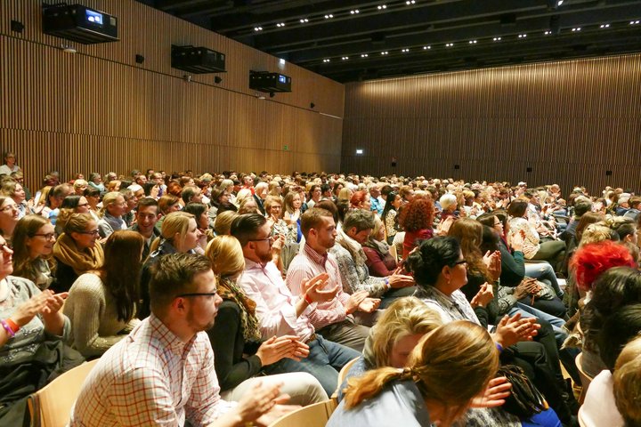 group of attendees sit and applaud in an auditorium at the Alpbach Forum