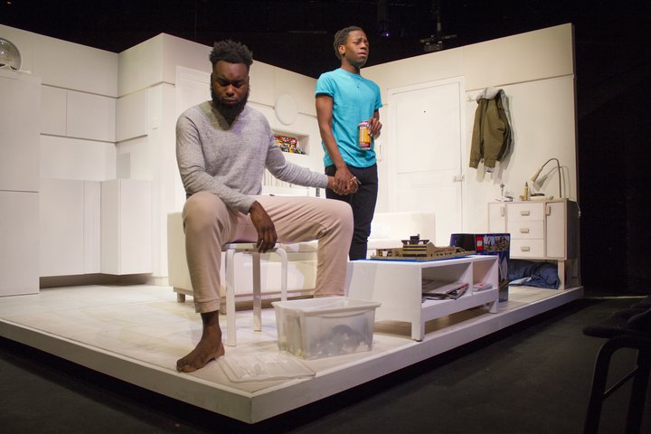 Two Acting students hold hands in a scene from bricks and pieces in RADA's Gielgud Theatre